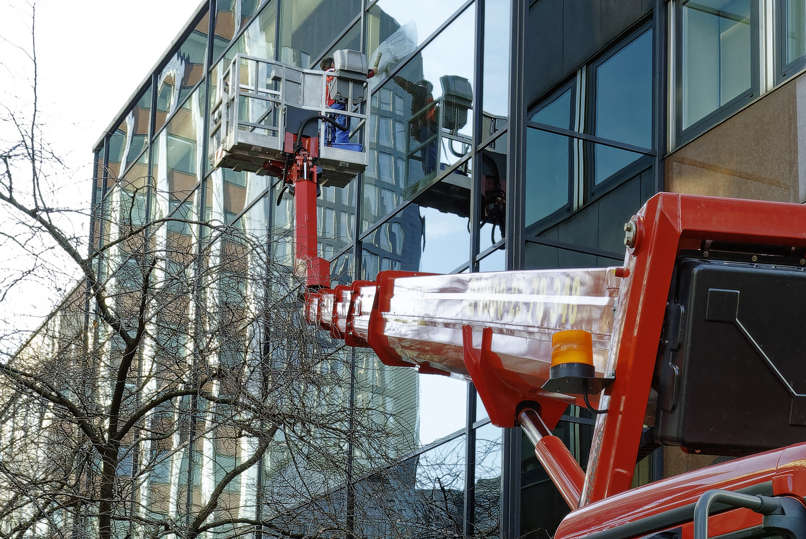 Gespiegelter Fensterputzer mit großem Besteck