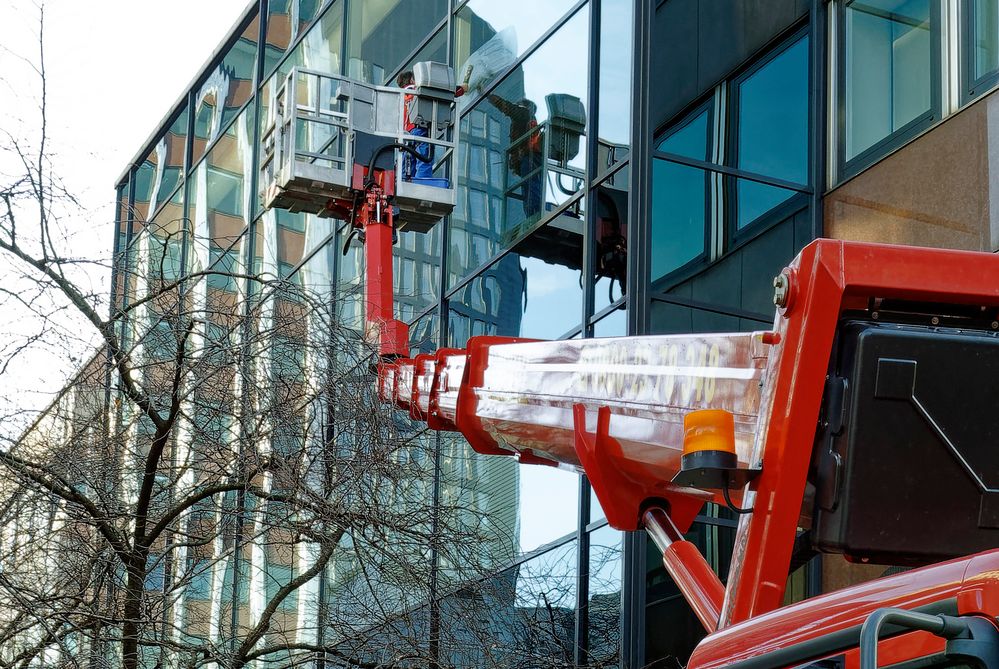 Gespiegelter Fensterputzer mit großem Besteck