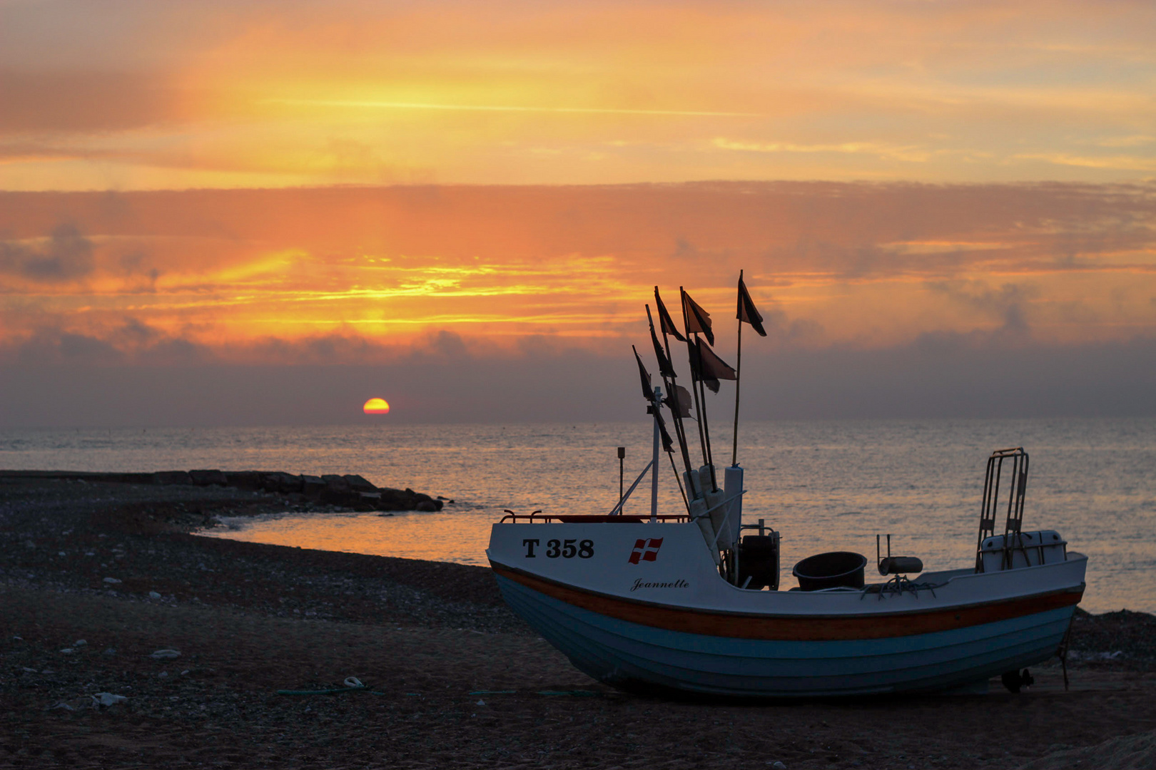 Gestrandetes Boot im Sonnenuntergang