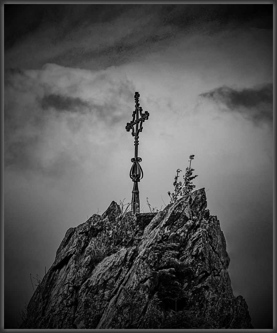 Gipfelkreuz mit dunklen Wolken