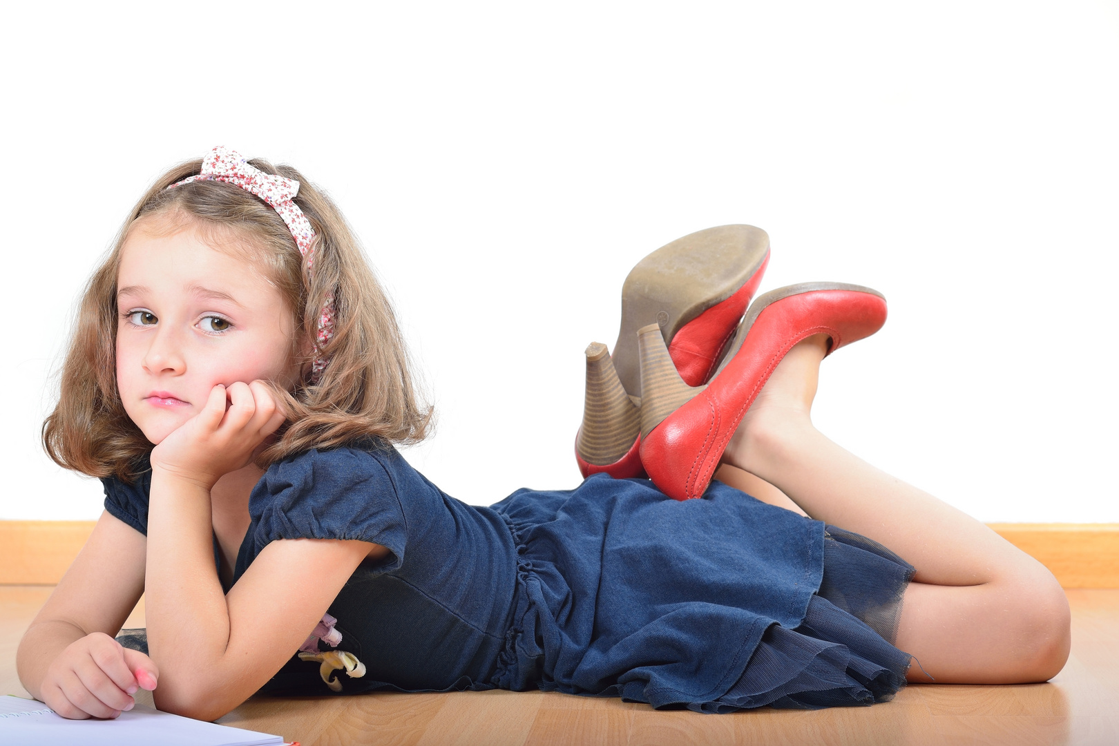 Girl wearing mother's shoes is reading and posing