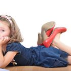 Girl wearing mother's shoes is reading and posing