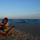 Gitarre spielend am Strand