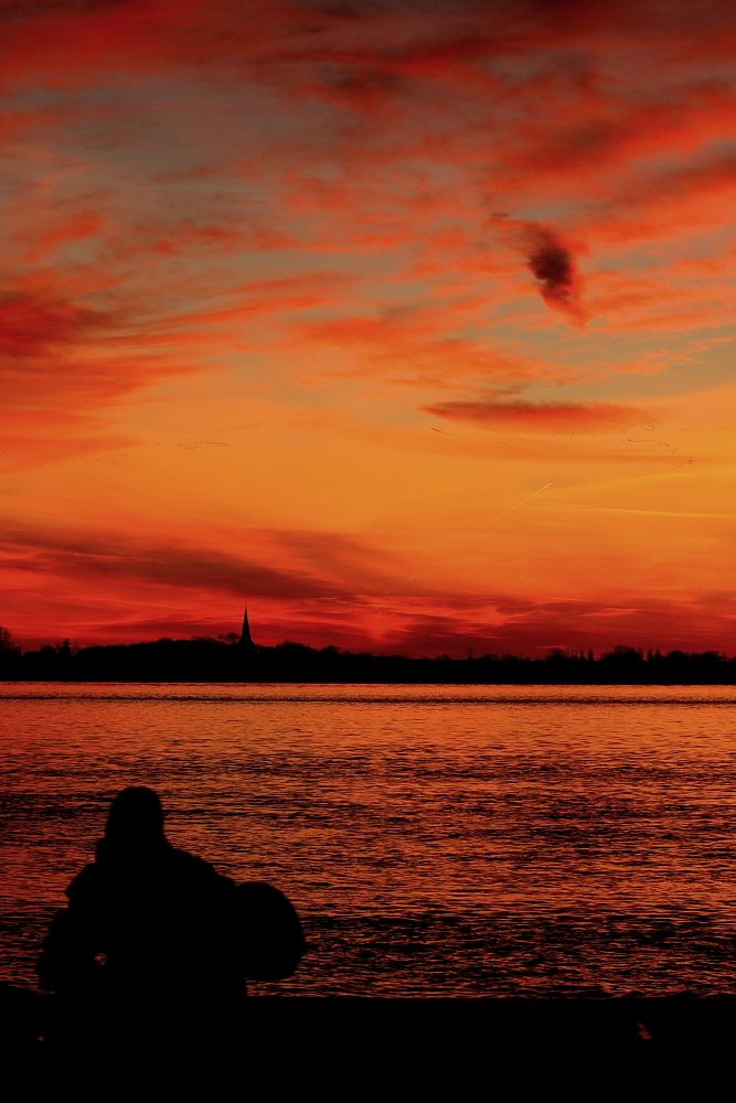 Gitarrenspieler am Meer im Sonnenuntergang.