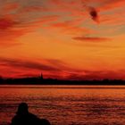 Gitarrenspieler am Meer im Sonnenuntergang.