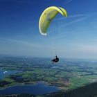 Gleitschirmflieger am Tegelberg mit Bannwaldsee Forggensee und Lechtal