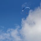 Gleitschirmflug unter blauem Himmel