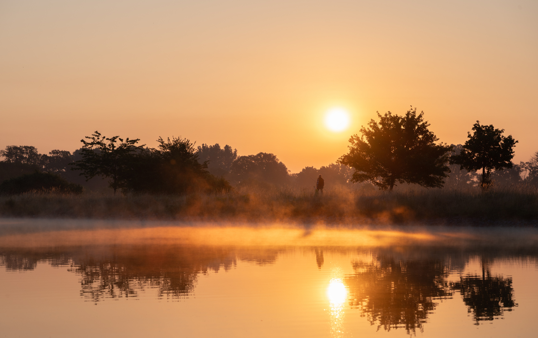 Goldene Stunde mit Wasser und Angler