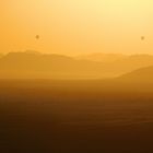 Goldener Sonnenaufgang mit Heißluftballons in weiter Ferne, beobachtet von Dune 45, Namibia