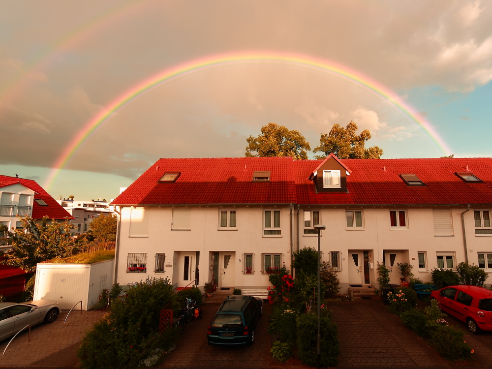 Graue Wolken über dem Regenbogen im Reihenhausparadies