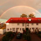 Graue Wolken über dem Regenbogen im Reihenhausparadies