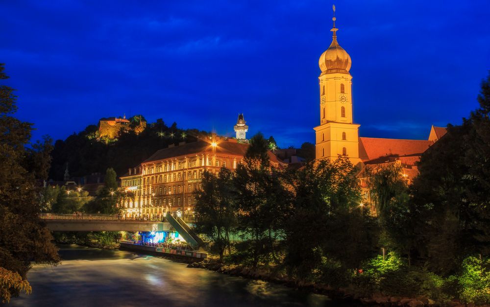 Graz bei Nacht mit Blick von der Franziskanerkirche zum Schloßberg