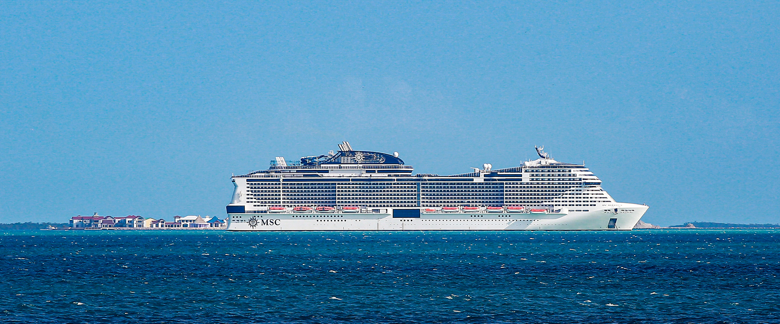 Großes Schiff vor kleiner Insel