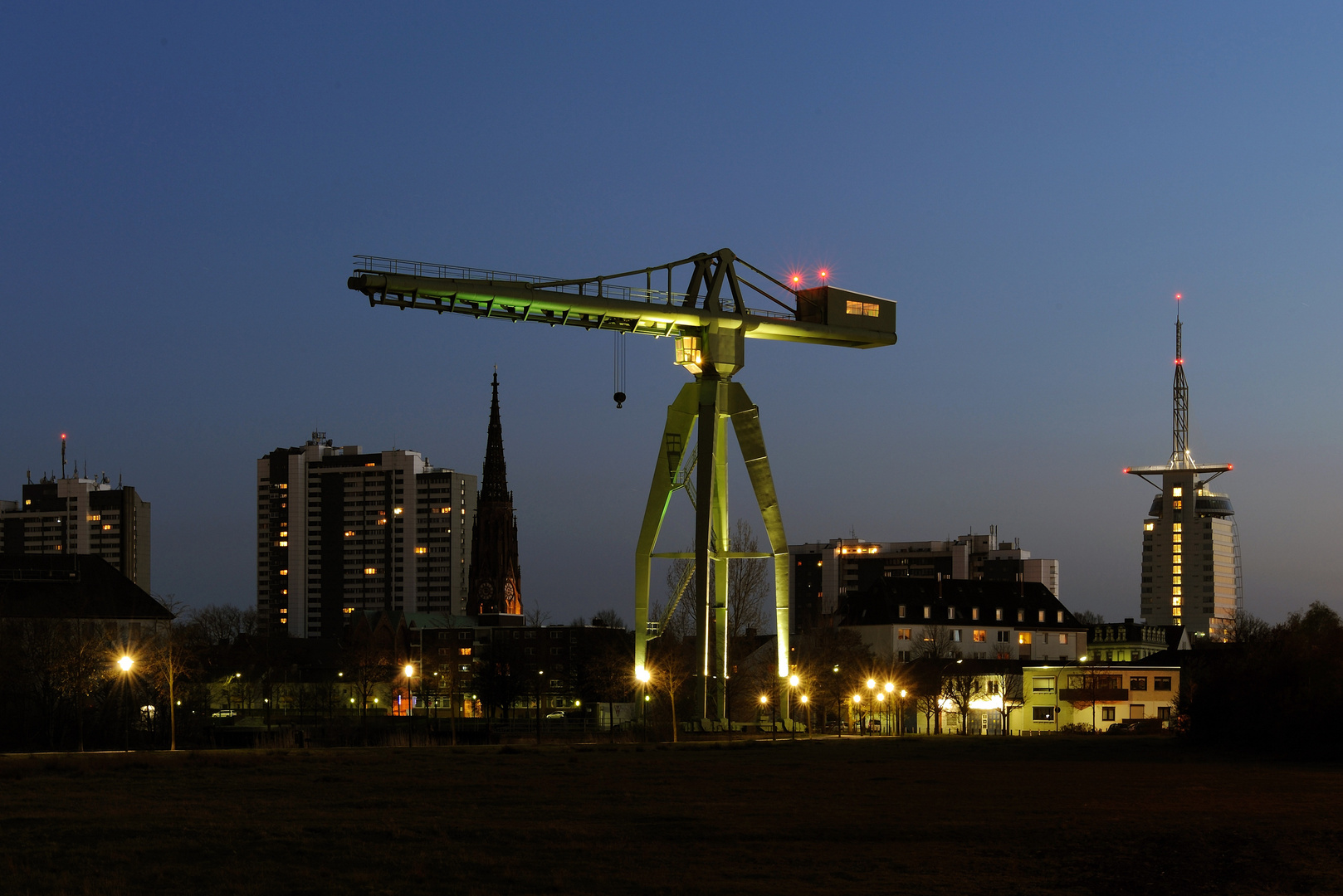 Grüner Kran in blauer Nacht