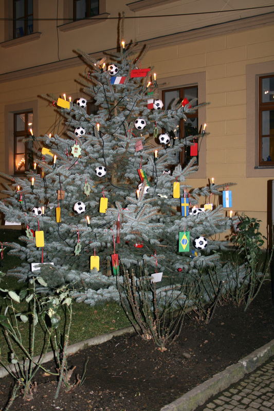 Grundschüler dekorieren einen Weihnachtsbaum