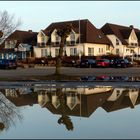 Häuser spiegeln sich nach viel Regen in einer großen Pfütze...