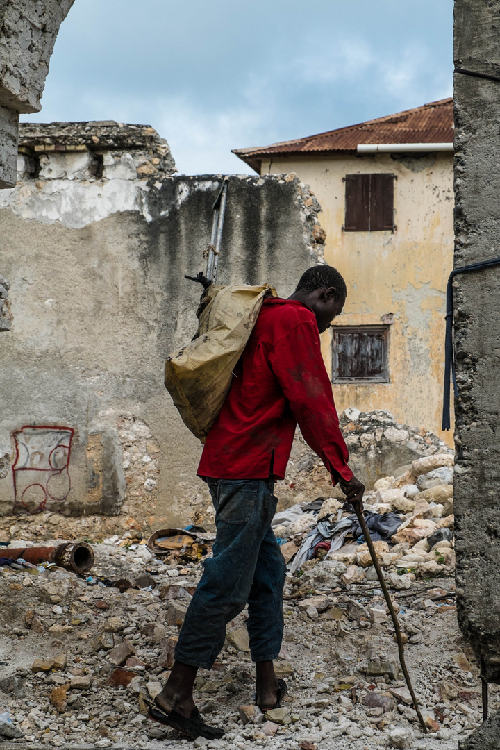 Haiti | Man walking through a building destroyed by an earthquake