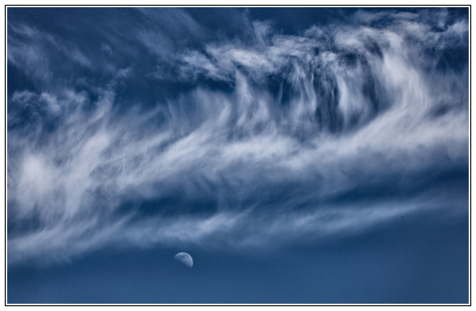 Halbmond unter Federwolken