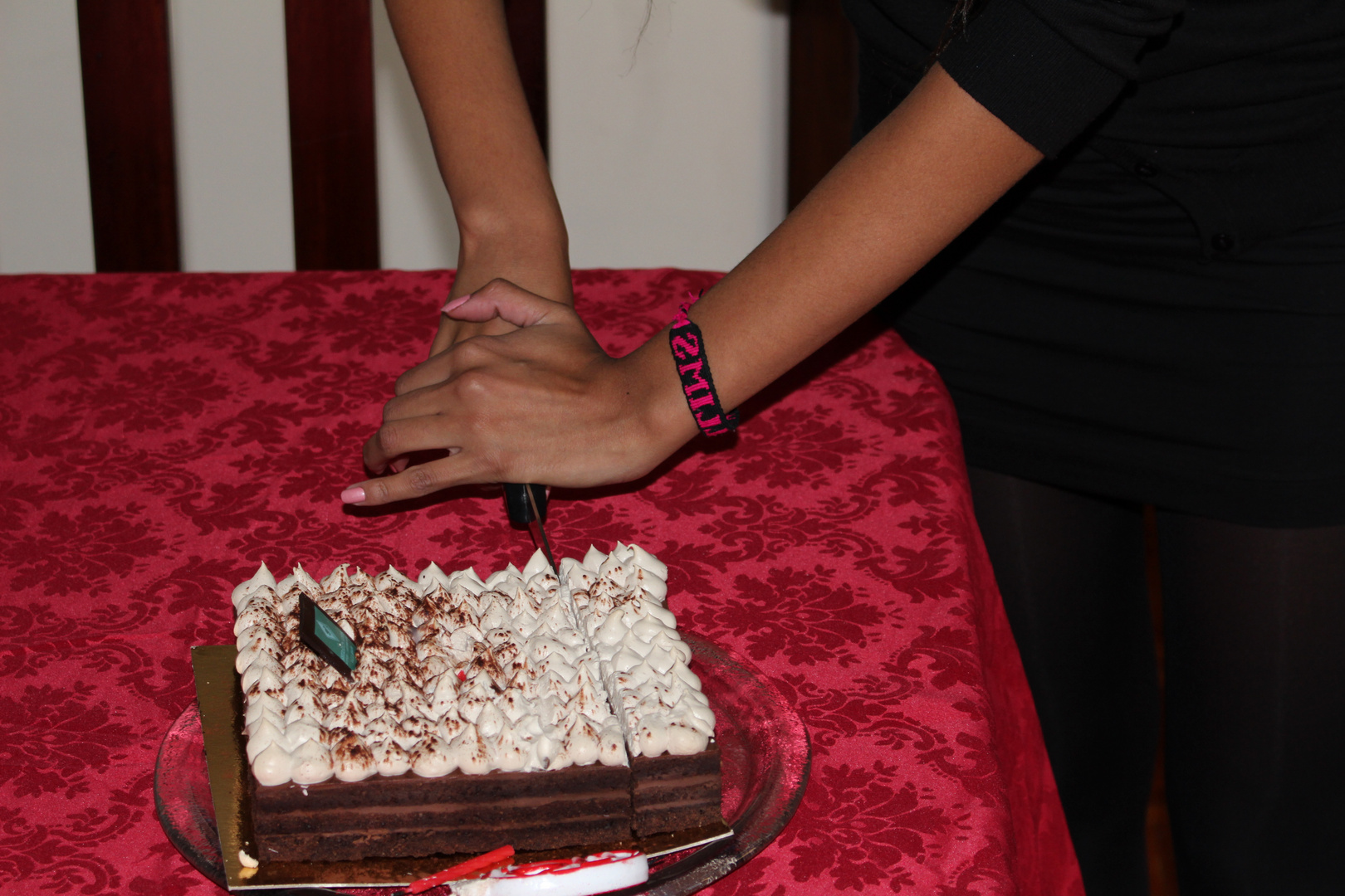 Hands cutting cake