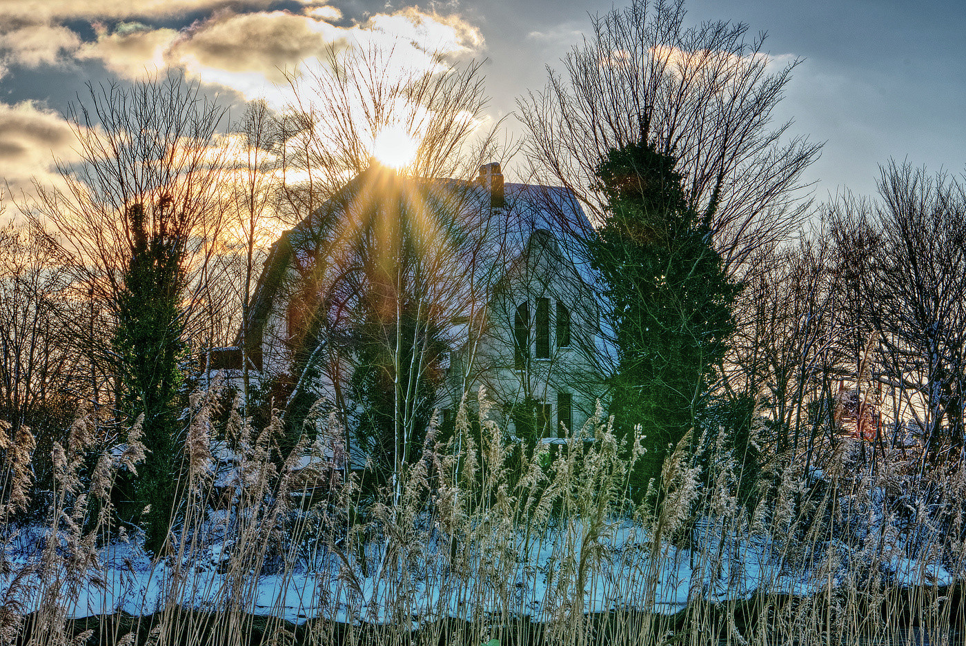 Haus mit Wintersonne am Fluss