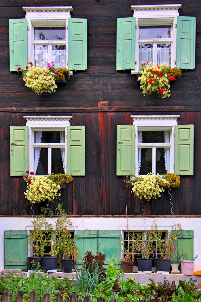 Hauswand mit grünen Fensterläden