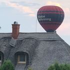 Heißluftballon über dem Reetdachhaus