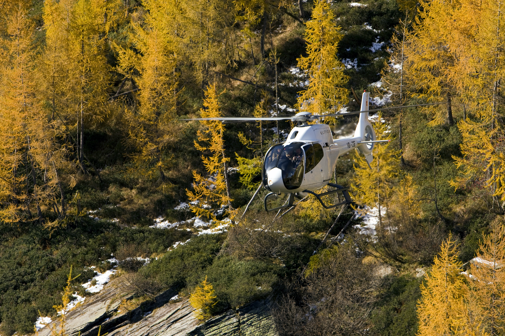 Helicopter fliegt über Herbstberge