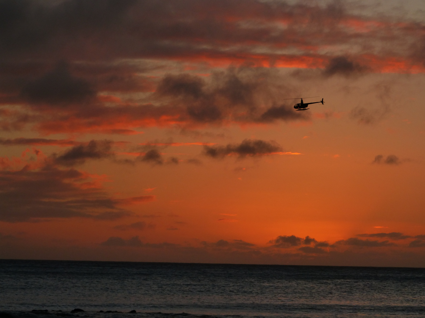 Helikopter vor dem Sonnenuntergang in den Pazifik