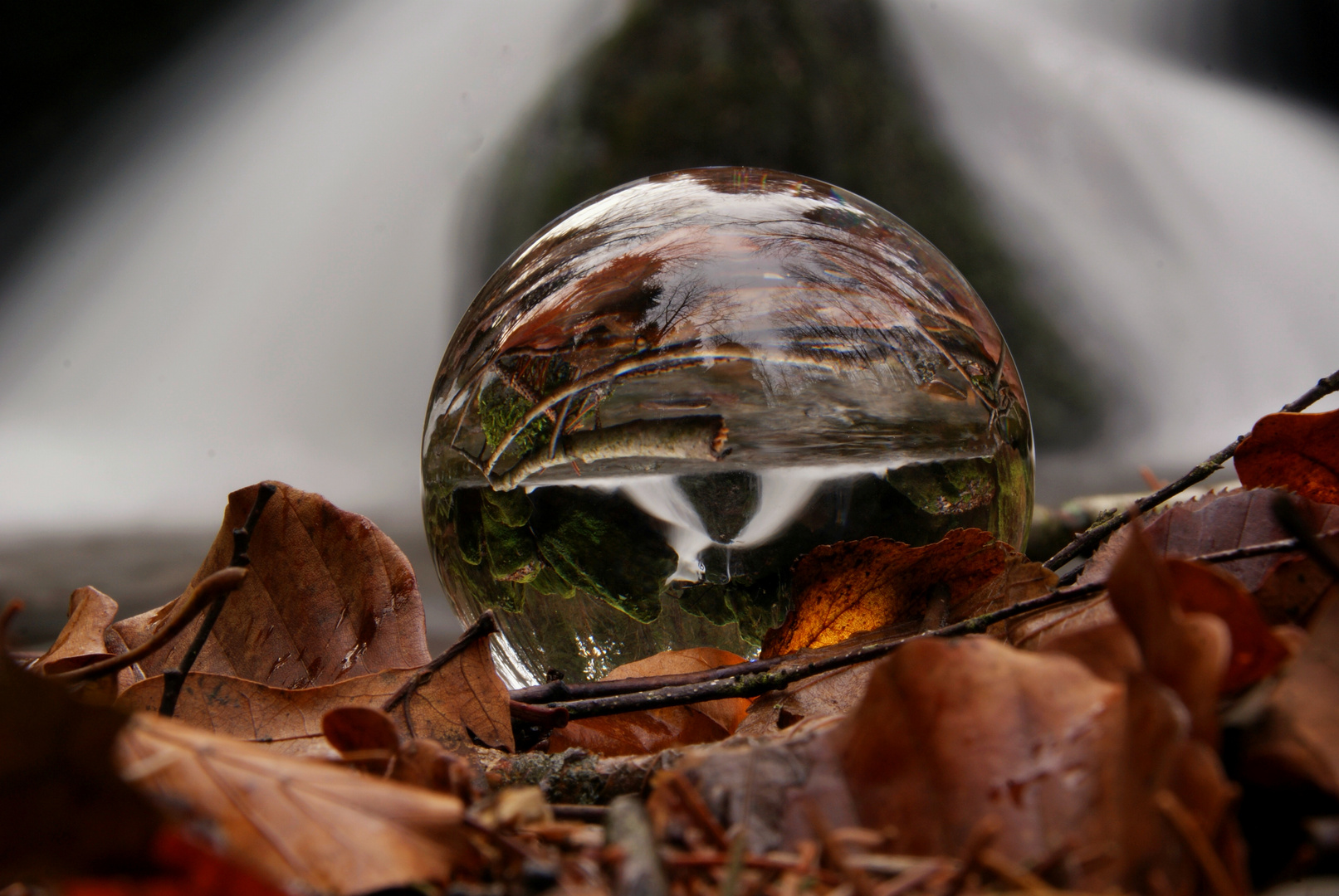 Herbstlicher Wasserfall in der Glaskugel