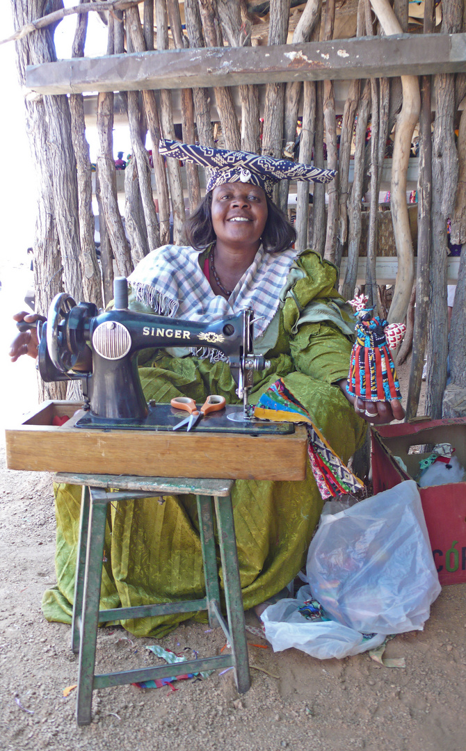 Herero-Schneiderin mit ihrem Werk