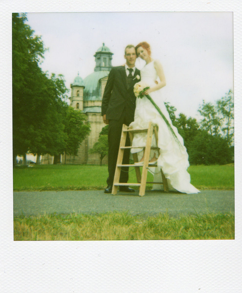 Herr und Frau H. vor der Kirche auf Polaroid gebannt
