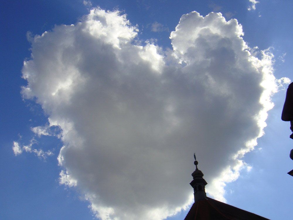 Herzförmige Wolke neben einem Kirchturm