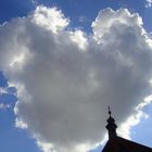 Herzförmige Wolke neben einem Kirchturm