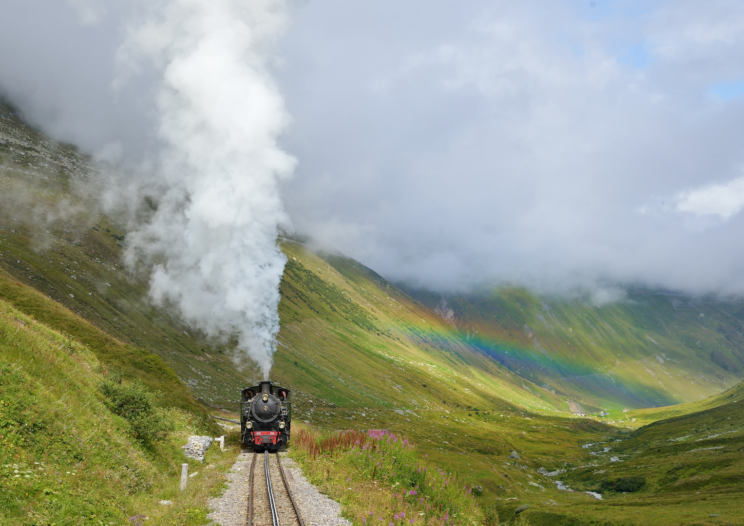 HG 704 --Dampfbahn Furka Bergstrecke-- am 30.08.21 auf dem Weg zum Furka mit Regenbogen