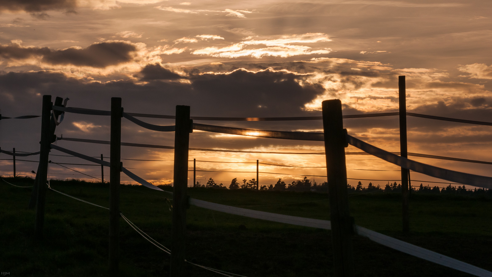 Hinterm Zaun geht die Sonne unter