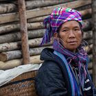 Hmong Frauen haben entweder ein Kind oder einen Korb am Rücken