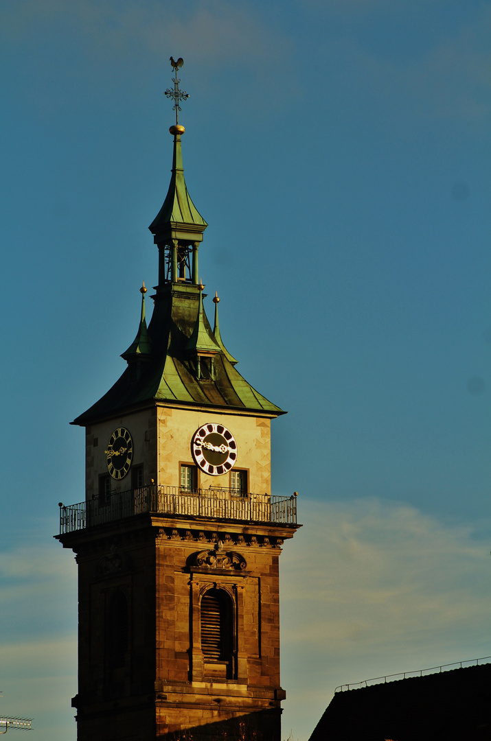 Hoch über Bad Canstatt der Kirchturm von der Sonne angestrahlt