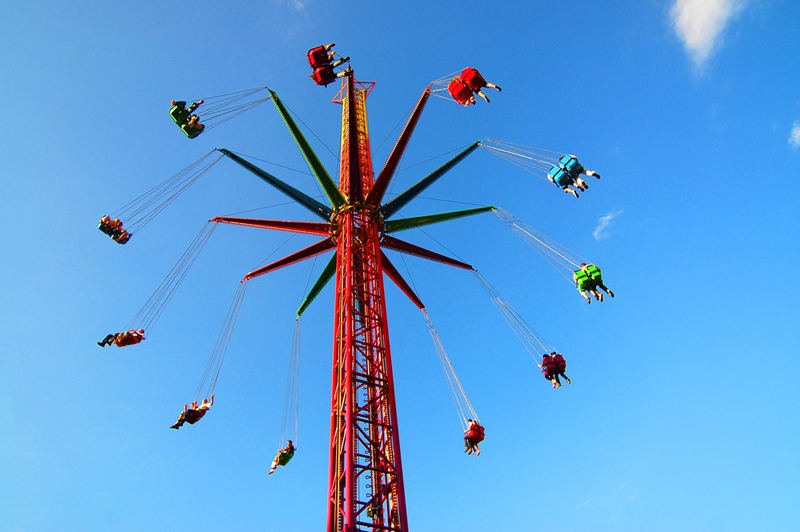 hoch über der Kirmes auf dem Kettenkarussell am Tag