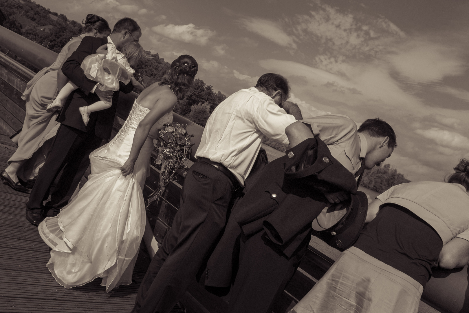 Hochzeitspaar und Gäste auf einer Brücke