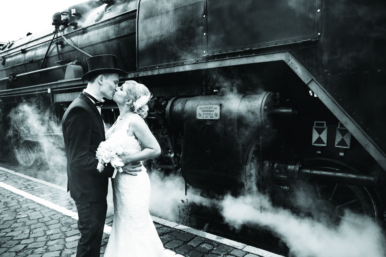 Hochzeitspaar vor historischer Eisenbahn 