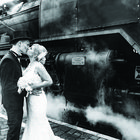 Hochzeitspaar vor historischer Eisenbahn 