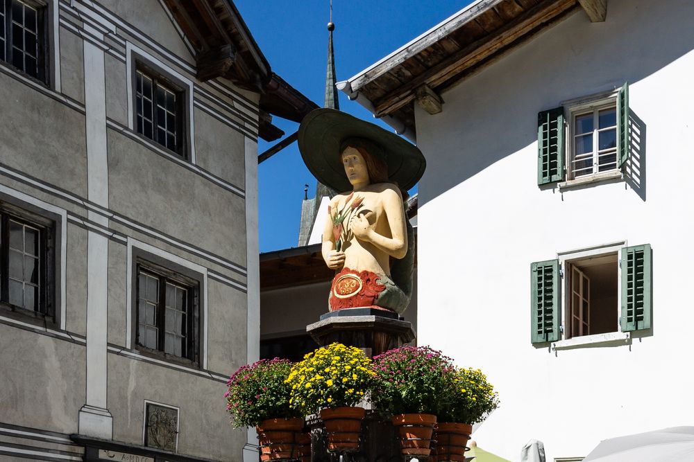 Hölzerne Wassernixe beim Dorfbrunnen von Valendas