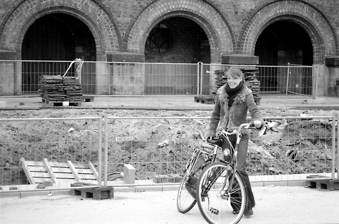 Holländisches Mädchen mit Fahrrad vor Baustelle vor Kirche