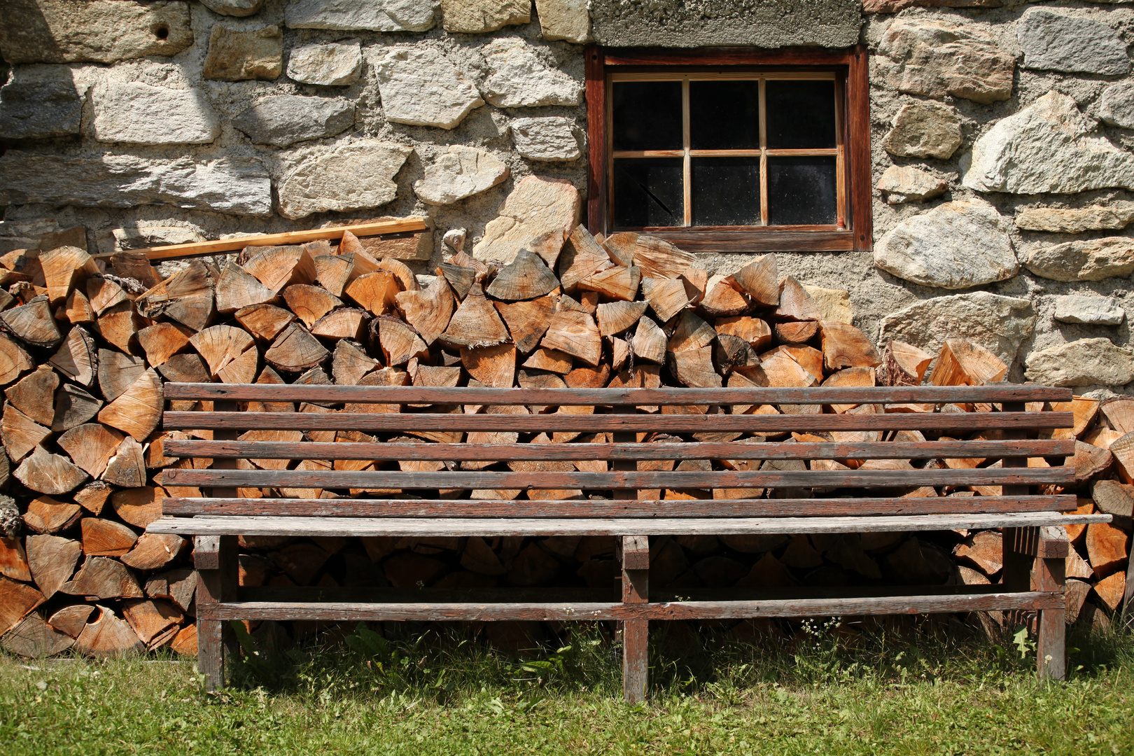 Holzbank vor Steinmauer