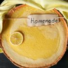 Homemade lemon pie on a yellow towel. Above view of dessert on a black table