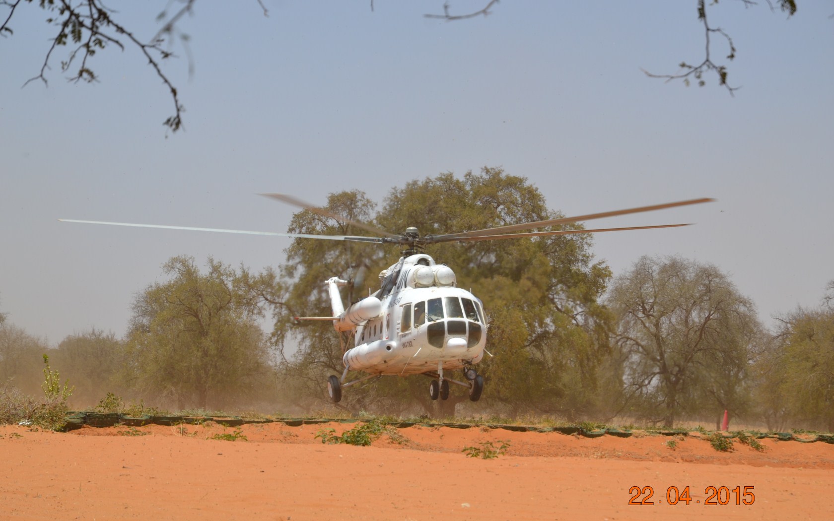 Hubschrauber bei Landung in Tockensavanne