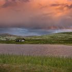 Hütten mit See in Landschaft von Norwegen im Sonnenuntergang