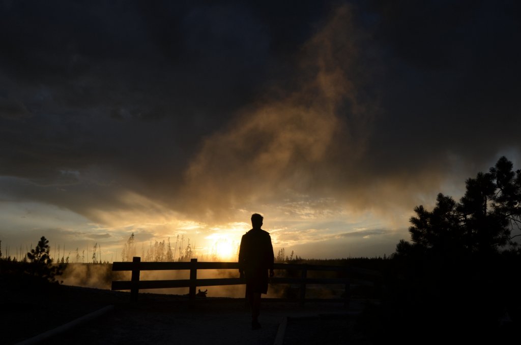 il bambino osserva i geyser al tramonto