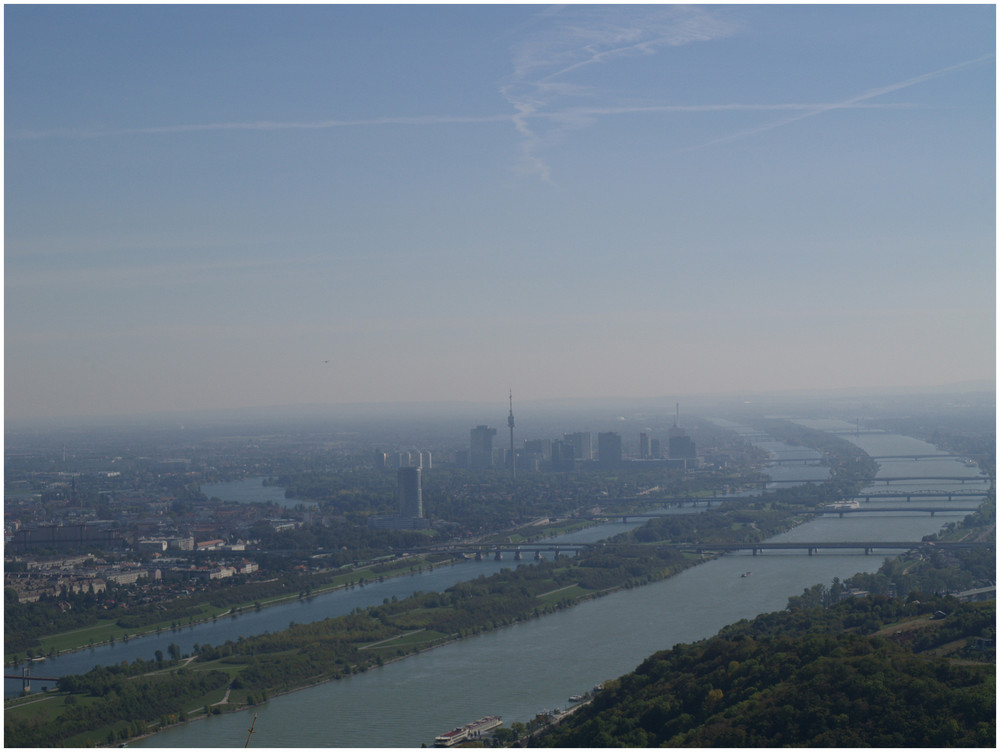 Im dunst sieht man die UNO city von wien, die donau und ihre zahlreichen brücken dies