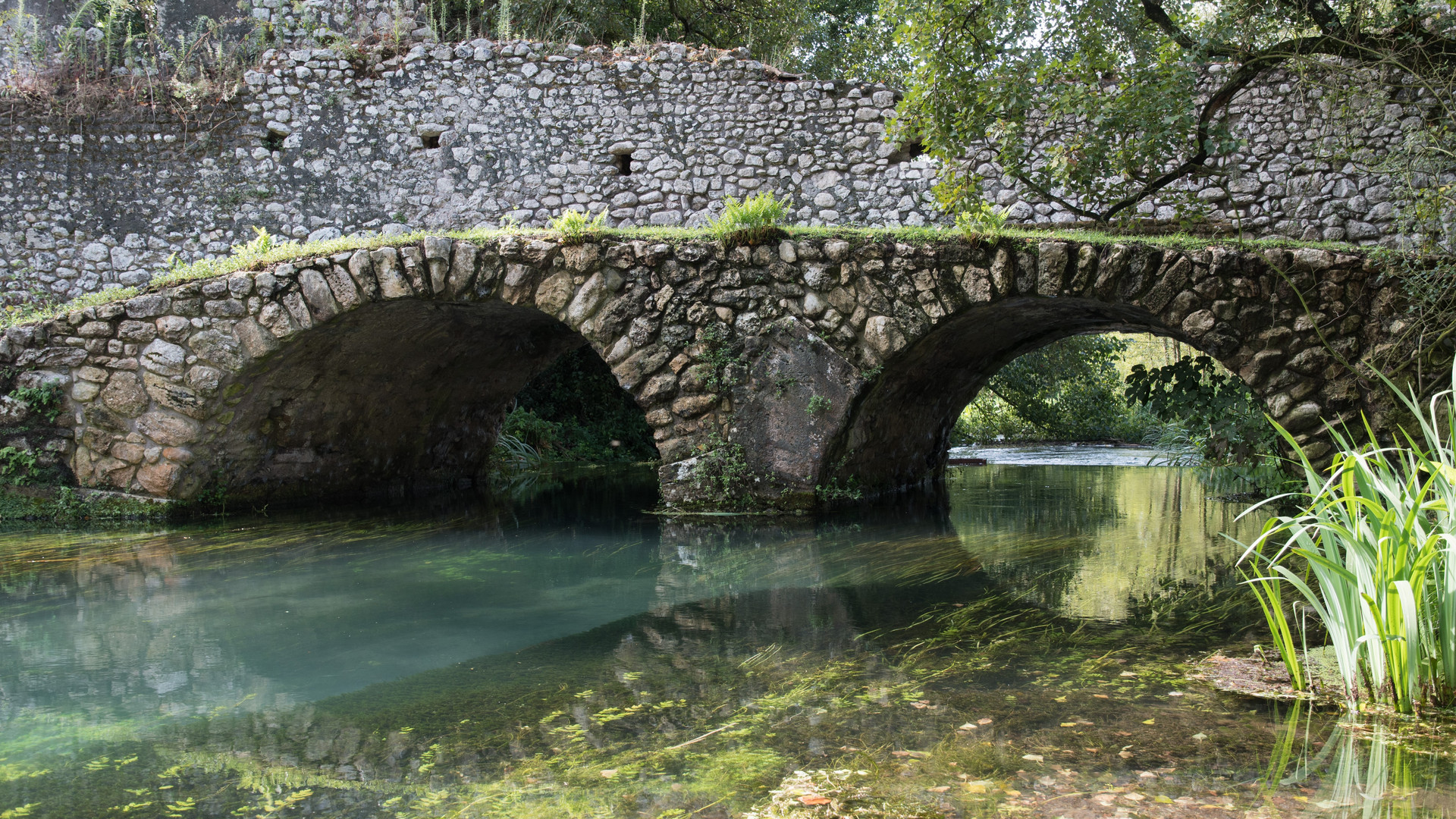 Im Garten von Ninfa, fliesender Bach mit Brücke Foto